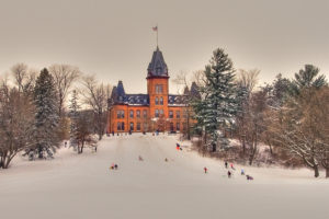 Photo of children sledding on a hill near Old Main at St. Olaf in Northfield, Minnesota