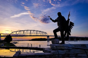 Photo of a statue of Chief Wapahasha II and the Wabasha-Nelson Bridge in Wabasha, Minnesota